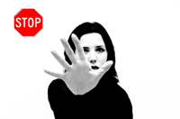 woman hand gestures to stop with a stop sign in background